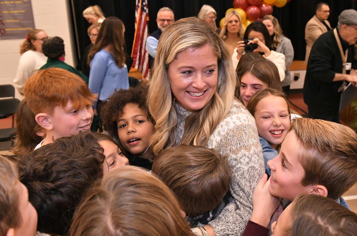 This is a photo of UK grad Jenna Stewart receiving a group hug from her class. Photo courtesy of the Milken Family Foundation.