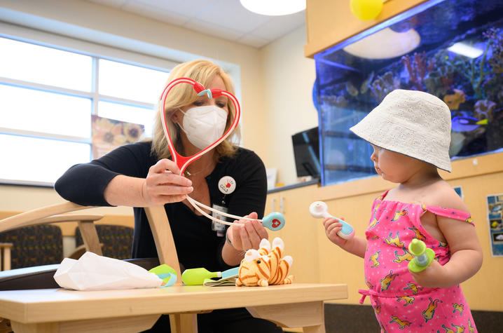 This is a photo of Jennifer Guilliams, director Child and Family Life at Kentucky Children’s Hospital, with a child. Photo by Adam Padgett.