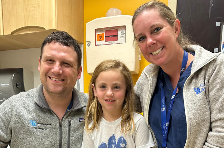 Three people posing for a picture in a hospital. 