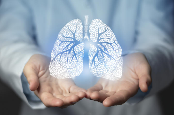 Doctor holding out hands with a white graphic of lungs overlaid. 