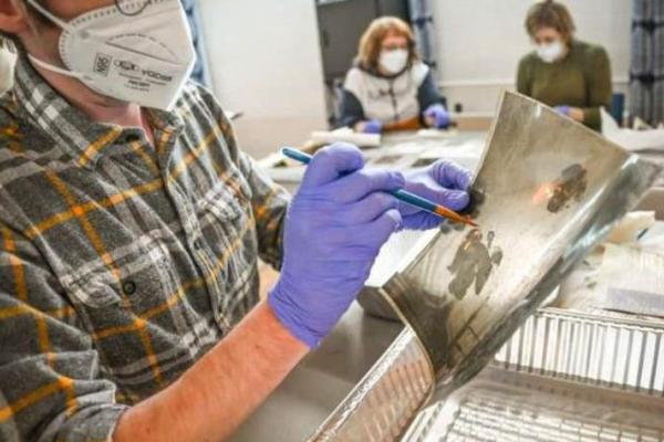 A volunteer at Hindman Settlement School helps restore a photograph following the massive Eastern Kentucky flood in July 2022. Flood waters irreparably damaged documents, photos and various works of art. Photo by Will Anderson.