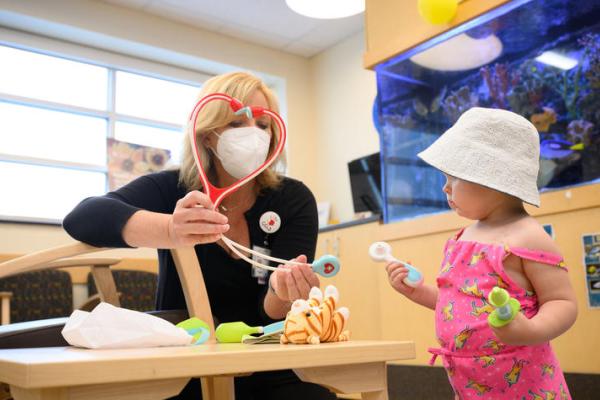 This is a photo of Jennifer Guilliams, director Child and Family Life at Kentucky Children’s Hospital, with a child. Photo by Adam Padgett.