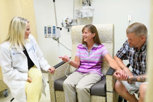 This is a photo of research nurse Heather Heath with Jenn and Tyrome Highfield inside the Precision Medicine Clinic at Markey Cancer Center.