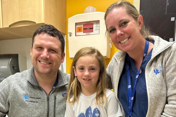 Three people posing for a picture in a hospital. 