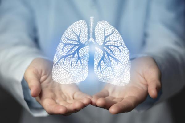 Doctor holding out hands with a white graphic of lungs overlaid. 