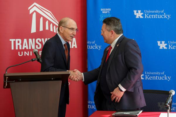 Two men shaking hands during press conference