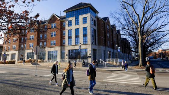 Students pass along the sidewalk in front of the Lewis Honors College.
