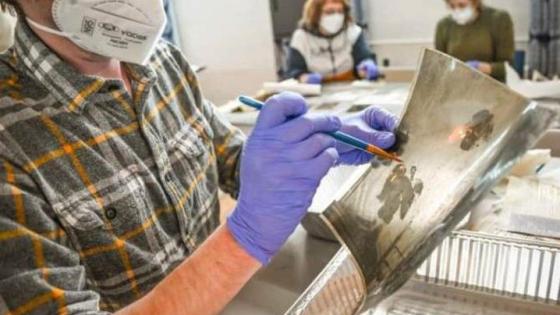 A volunteer at Hindman Settlement School helps restore a photograph following the massive Eastern Kentucky flood in July 2022. Flood waters irreparably damaged documents, photos and various works of art. Photo by Will Anderson.