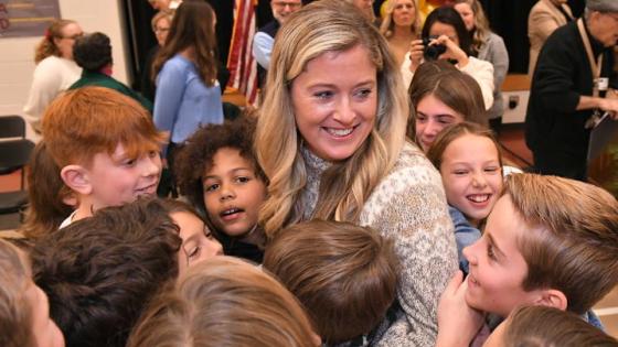 This is a photo of UK grad Jenna Stewart receiving a group hug from her class. Photo courtesy of the Milken Family Foundation.