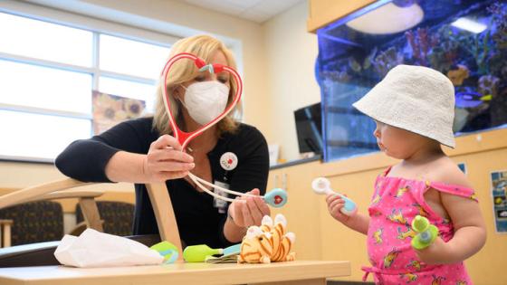 This is a photo of Jennifer Guilliams, director Child and Family Life at Kentucky Children’s Hospital, with a child. Photo by Adam Padgett.