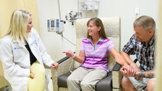 This is a photo of research nurse Heather Heath with Jenn and Tyrome Highfield inside the Precision Medicine Clinic at Markey Cancer Center.
