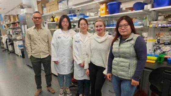 Five people standing in a lab facing the camera.