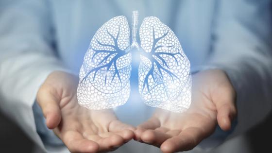 Doctor holding out hands with a white graphic of lungs overlaid. 