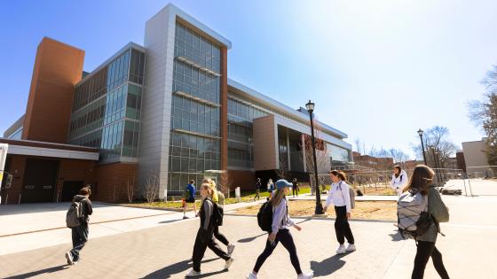 Students walking by the updated chemistry building on a sunny day