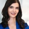 Woman in blue shirt posing for a headshot.